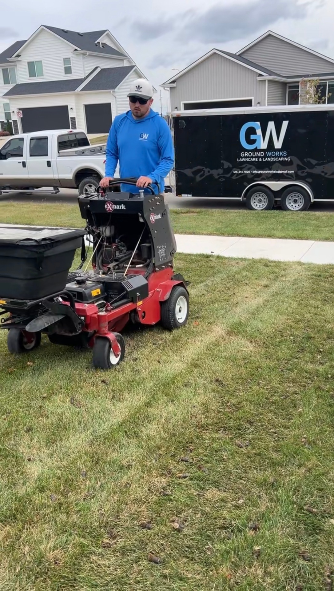 Operator on Exmark aerator with seeder attachment in an Ankeny yard